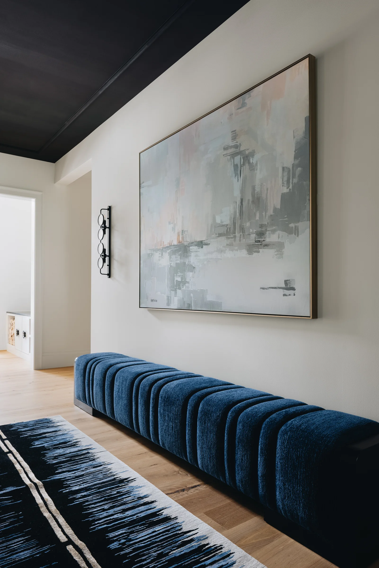 Gallery-like hallway with blue upholstered bench